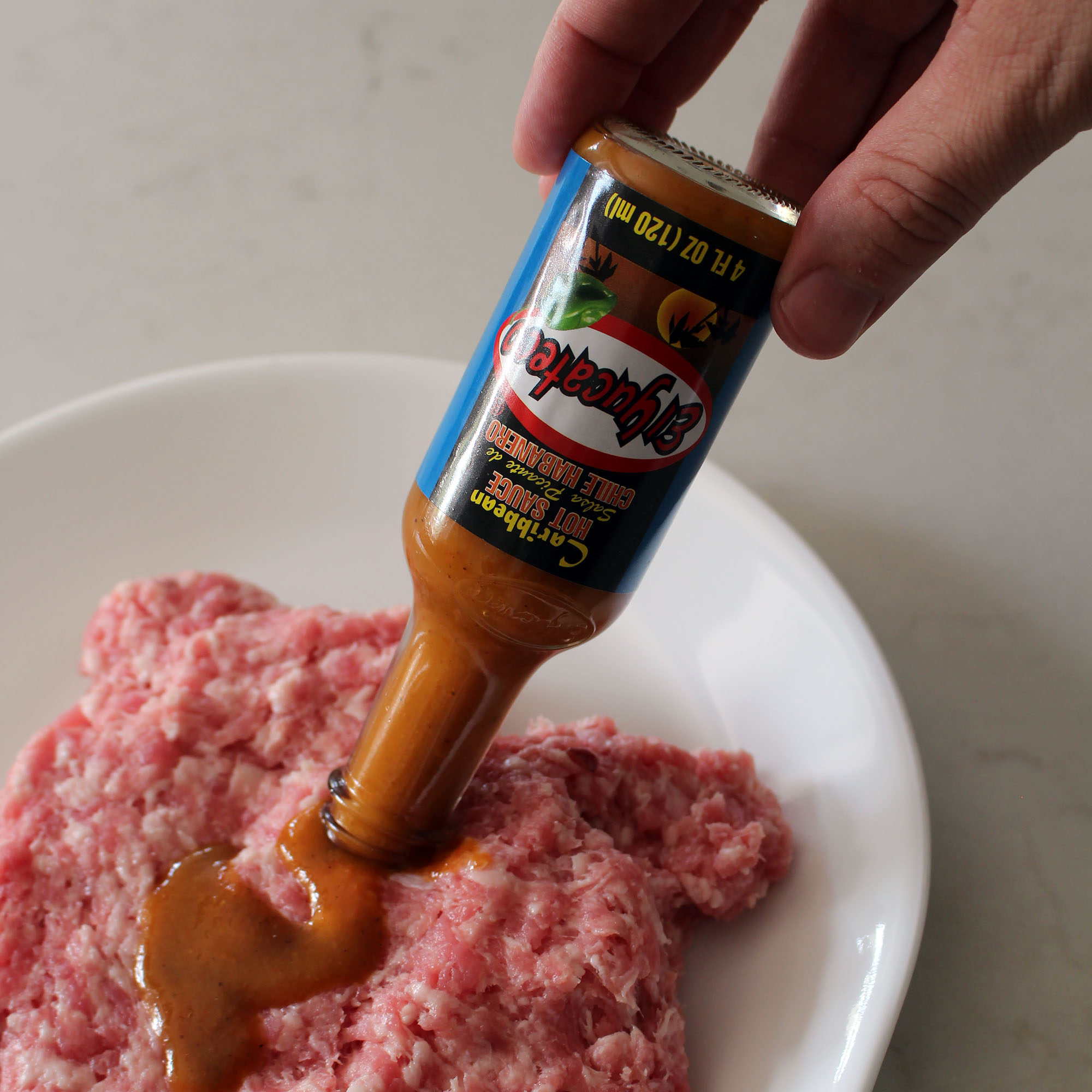 Adding El Yucateco hot sauce to the ground pork Food