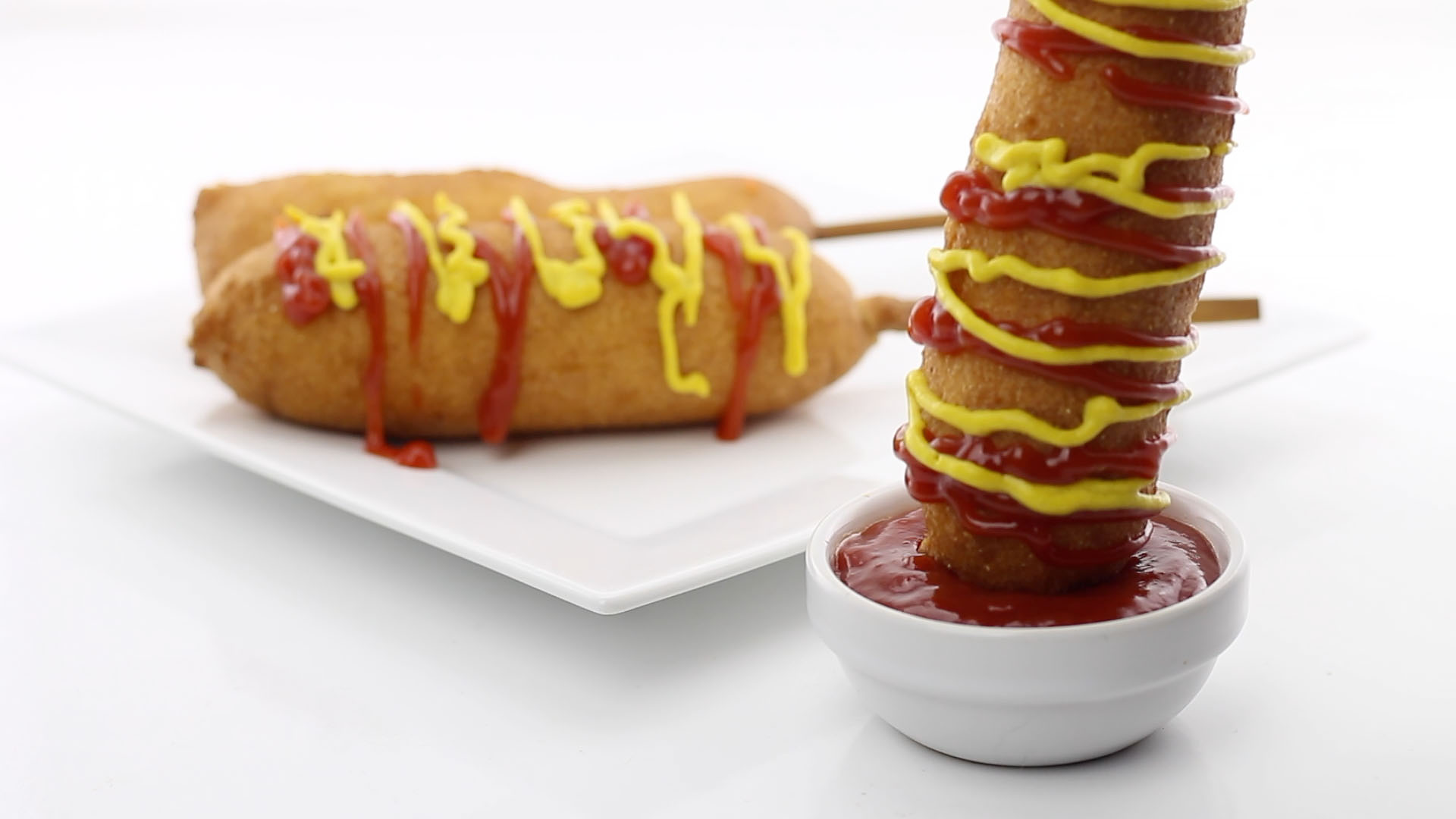 Corn dog being dipped in ketchup